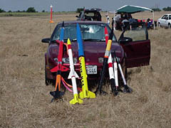 Rockets propped up against a Saturn sedan