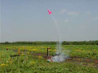 Pink two stage rocket in flight