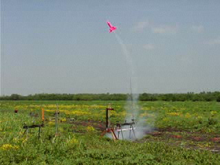 Pink two stage rocket in flight